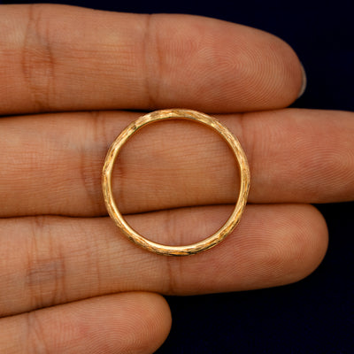 A Chevron Branches Band lying flat in a models hand to show the thickness of the Ring