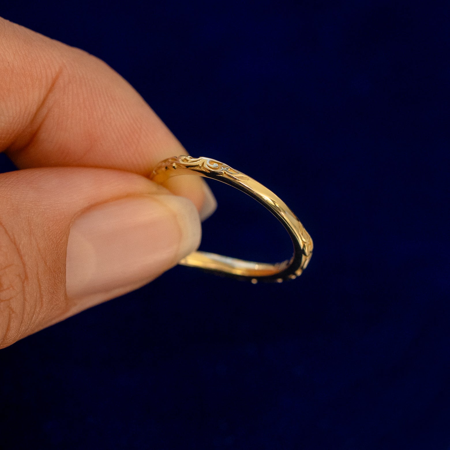 A model holding a Chevron Filigree Band backward to show the details of the back of the band