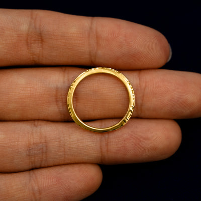 A Chevron Filigree Band lying flat in a models hand to show the thickness of the Ring