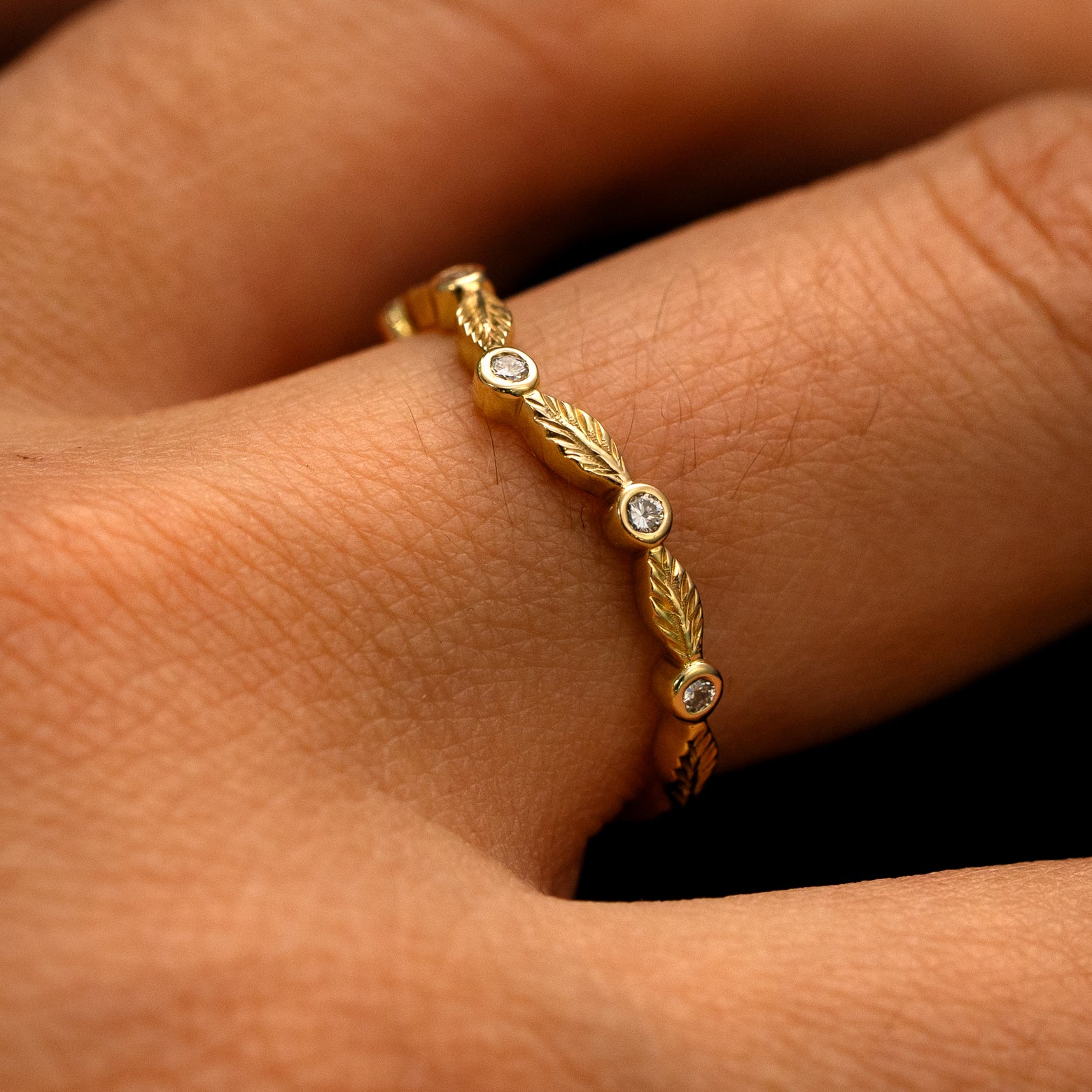 Side view of a Chevron Leaves and Round Diamonds Band on a model's finger