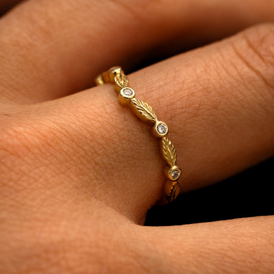Side view of a Chevron Leaves and Round Diamonds Band on a model's finger