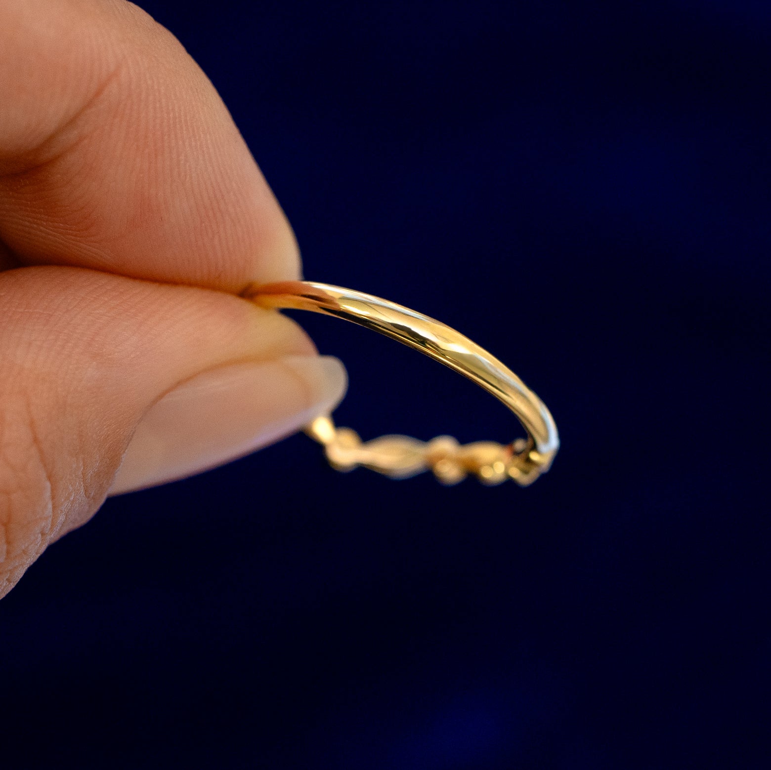 A model holding a Chevron Leaves and Round Diamonds Band backward to show the details of the back of the band