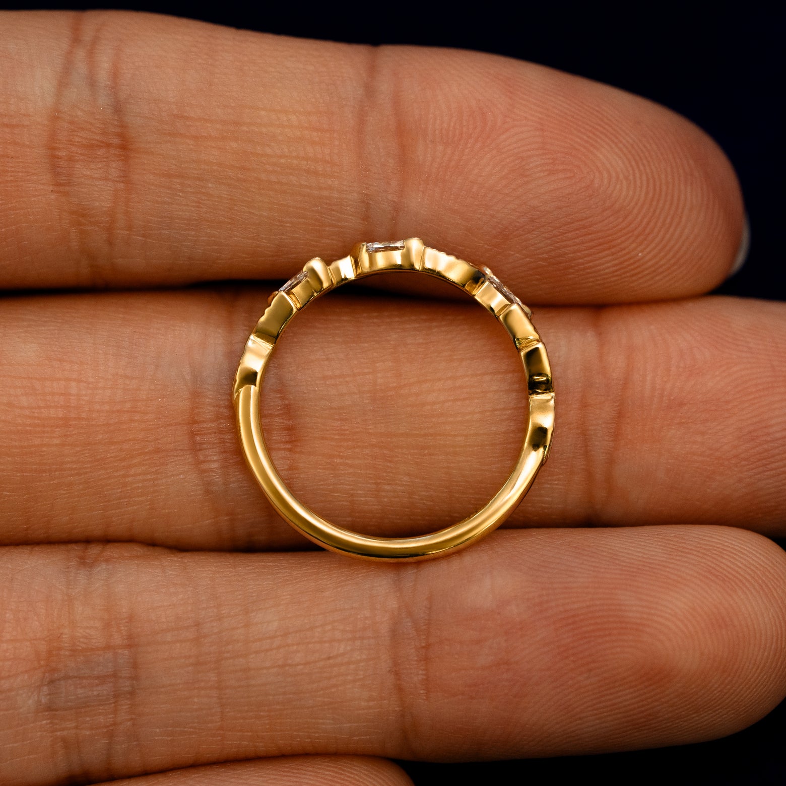 A Chevron Leaves and Marquise Diamonds Band lying flat in a models hand to show the thickness of the Ring