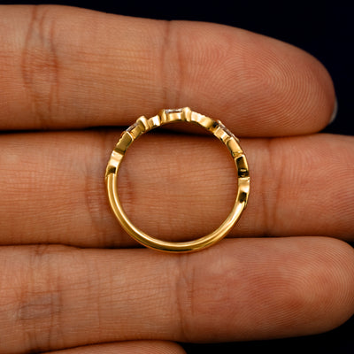 A Chevron Leaves and Marquise Diamonds Band lying flat in a models hand to show the thickness of the Ring