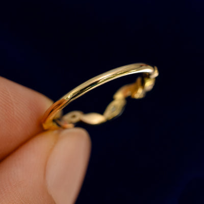 A model holding a Chevron Leaves and Marquise Diamonds Band backward to show the details of the back of the band