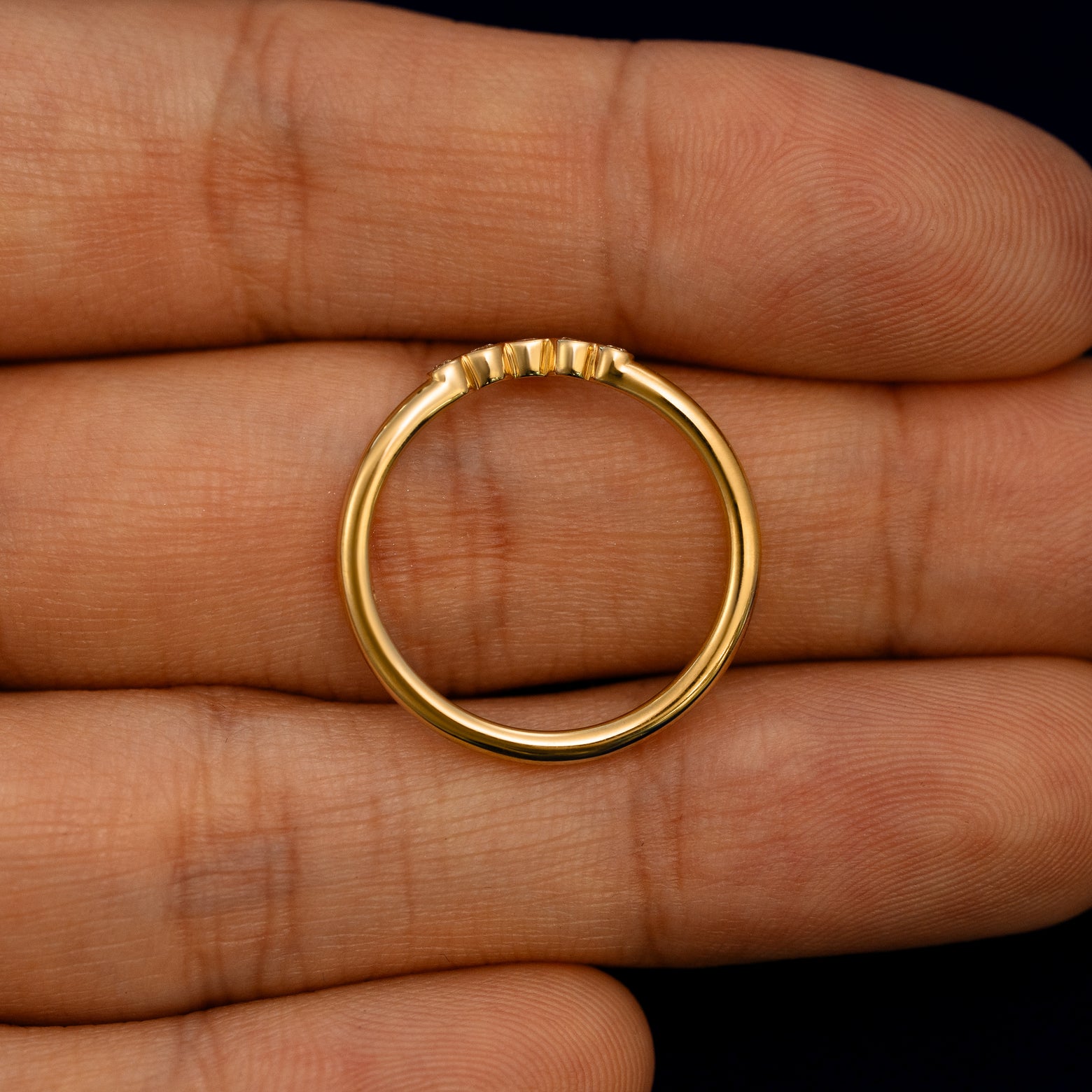 A Chevron Tiara Diamond Band lying flat in a models hand to show the thickness of the Ring