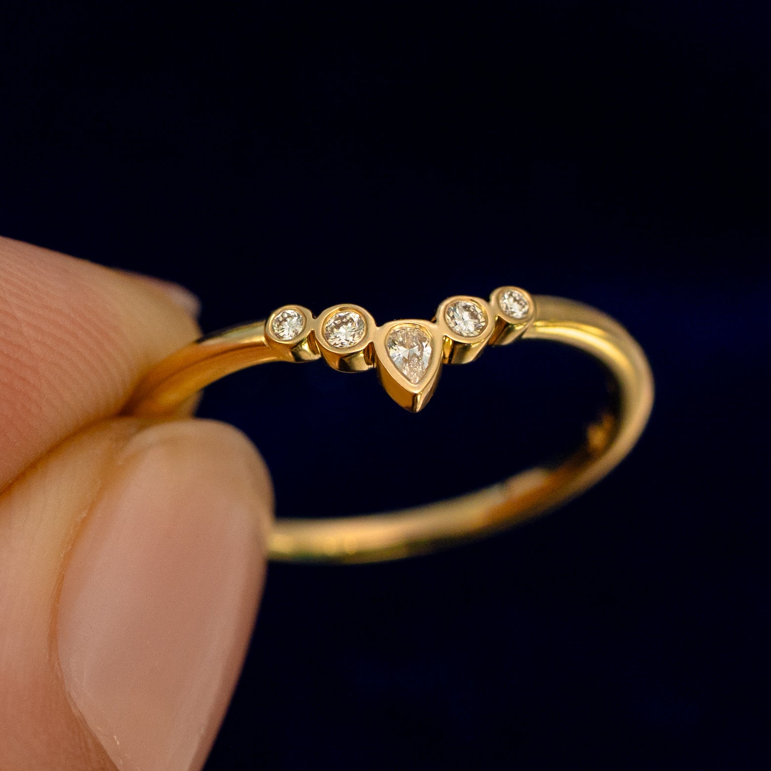 A model holding a Chevron Tiara Diamond Band up to show the details of the design and the inside of the ring