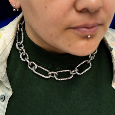 A photo of a silver chunky chain on a model's neck