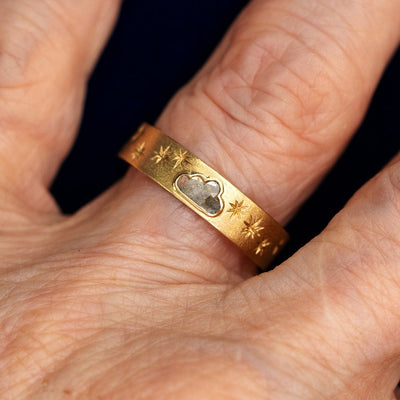Close up view of a model's fingers wearing a 14k yellow gold Cloud Diamond Band