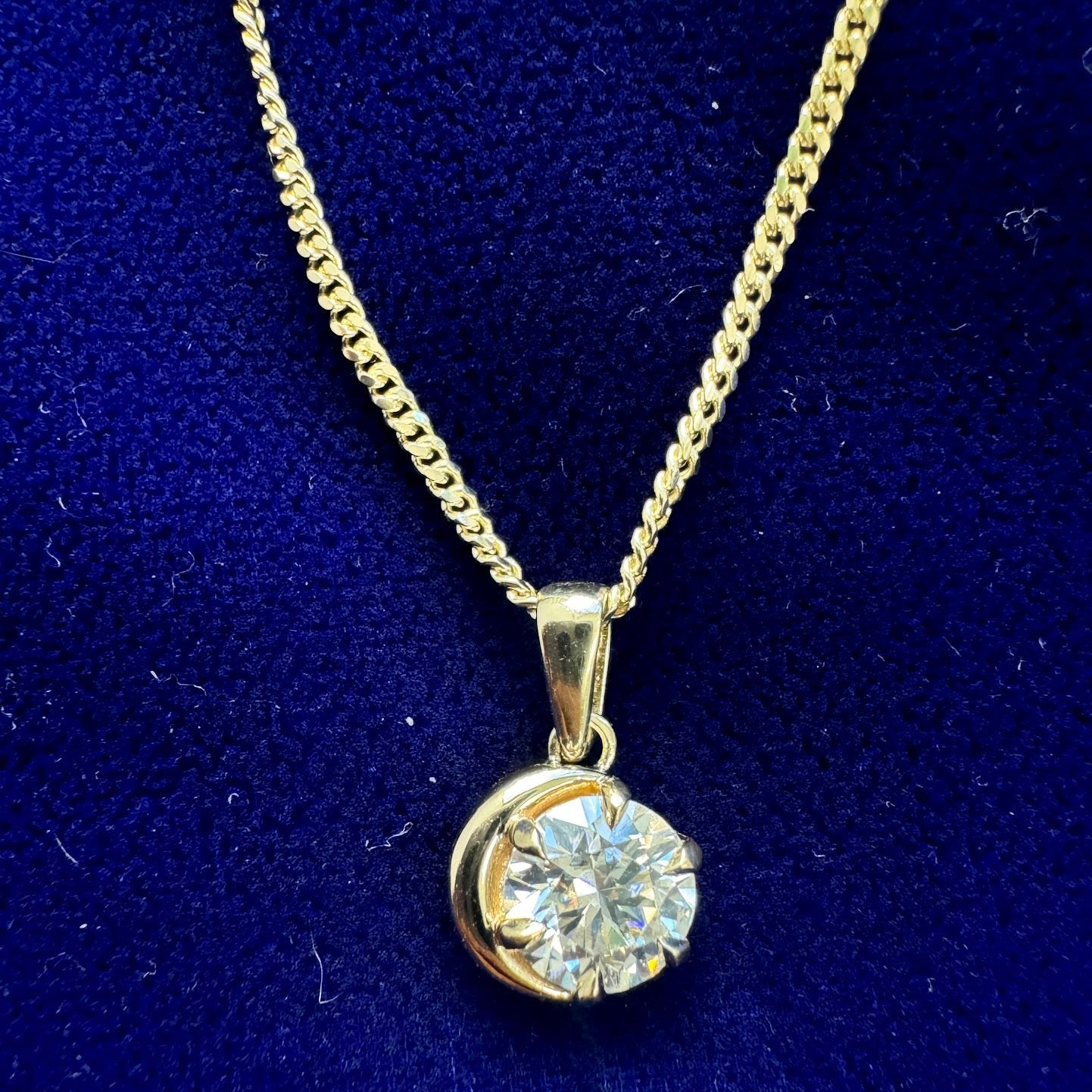 A solid yellow gold crescent moon and moissanite pendant on a 14k mini miami chain