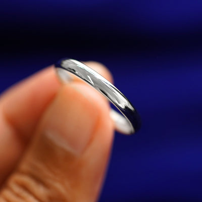 A model holding a Silver Curvy Mirror Band tilted to show the curve of the band