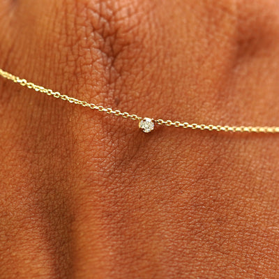 Close up view of a 14k yellow gold Diamond Cable Necklace draped across the back of a model's hand