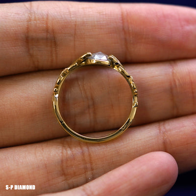 A yellow gold Salt and Pepper Leaves Ring in a model's hand showing the thickness of the band