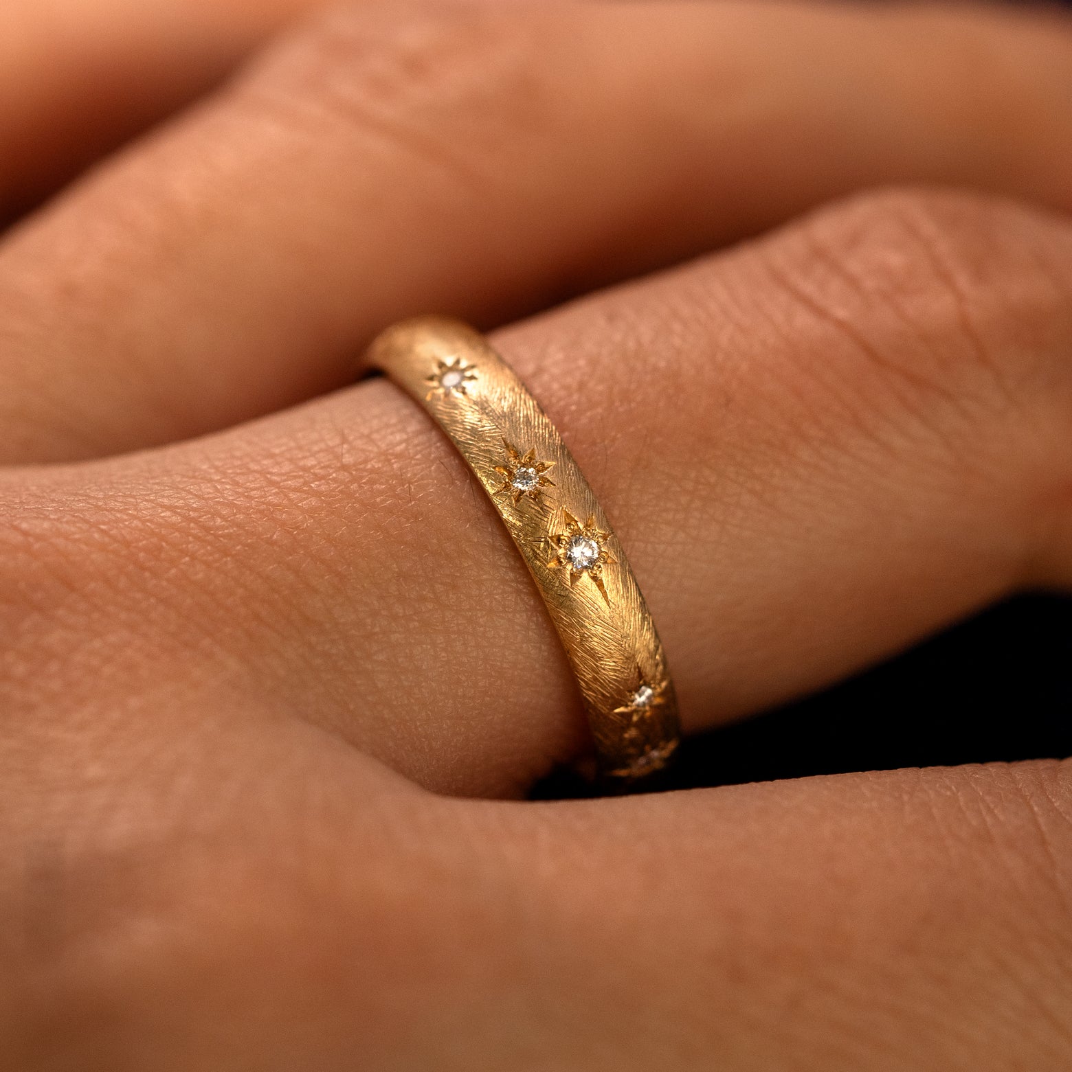 Side view of a Curvy Diamond Stars Velvet Band on a model's finger