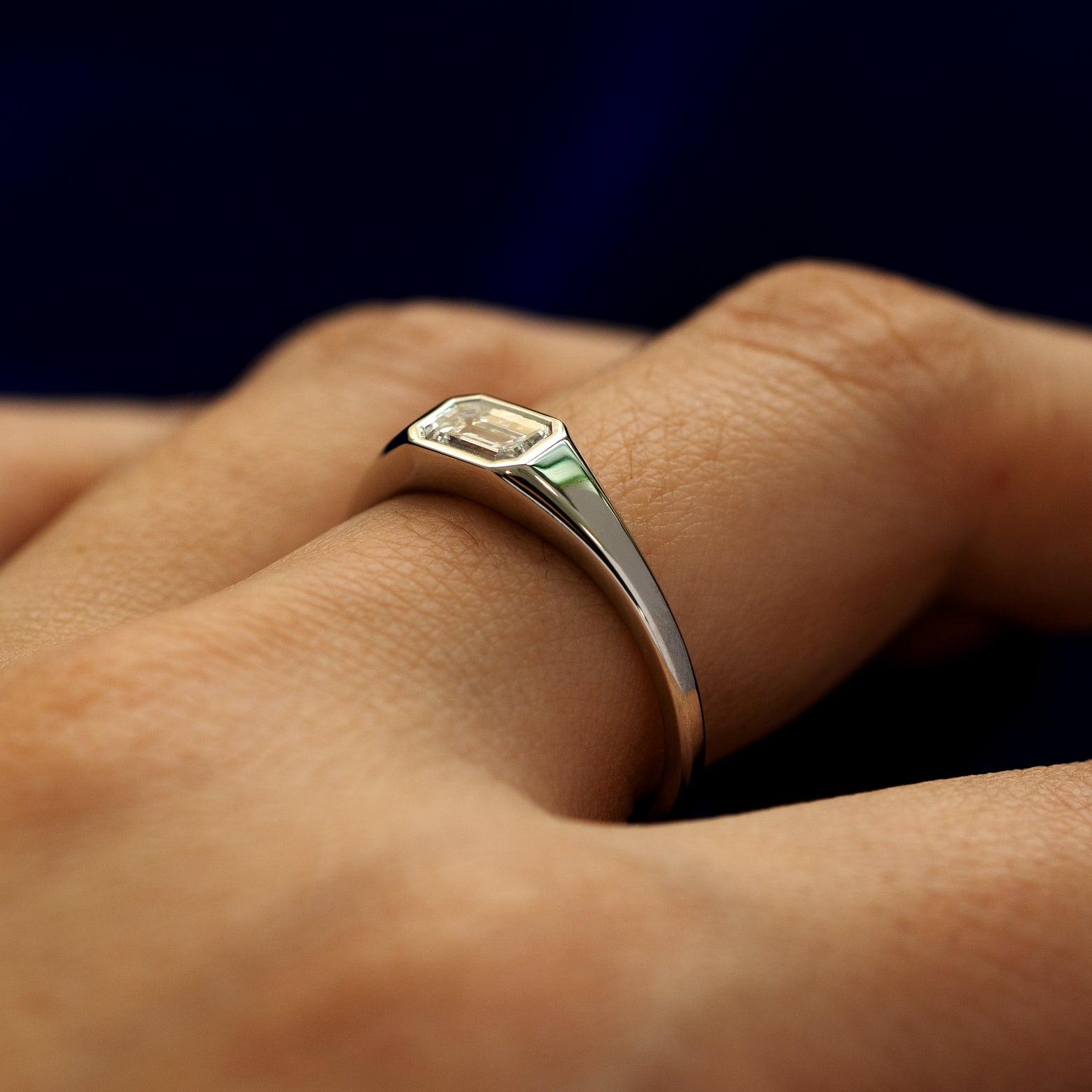 Side view of a Emerald Cut Lab Created Diamond Signet Ring on a model's finger to show details