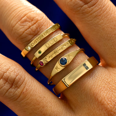 A model wearing five different engravable bar rings stacked on one finger