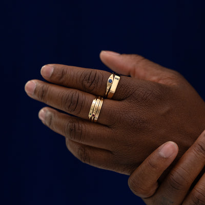 A models hand wearing stacks of different engravable bar rings from our collections