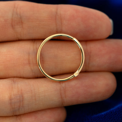 A bezel set gemstone bar ring laying flat in a models hand to show the thickness of  the band