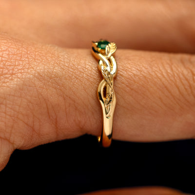 Side view of a Gemstone Leaves and Vines Ring on a model's finger to show the detailing of the braided vines and leaves