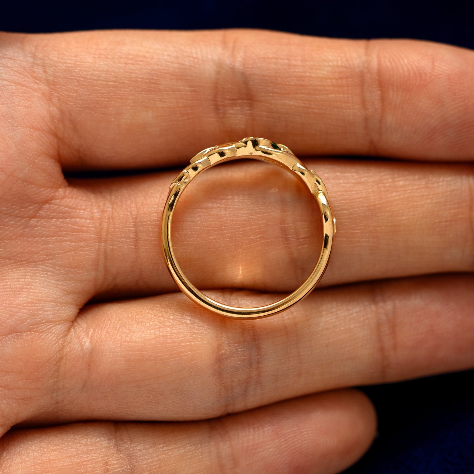 An top down  view of a Gemstone Leaves and Vines Ring resting on a model's fingers to show the thickness of the band