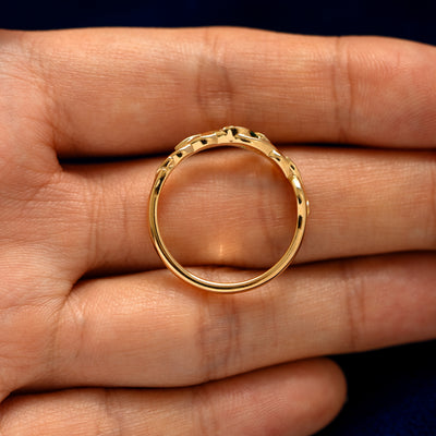 An top down  view of a Gemstone Leaves and Vines Ring resting on a model's fingers to show the thickness of the band