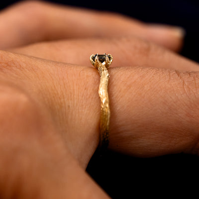Side view of a Montana Teal Sapphire Waved Branch Ring on a model's finger to show the detailing of the setting