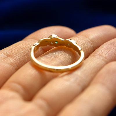 A yellow gold Gemstone Leaves and Vines Ring in a model's hand showing underneath the setting