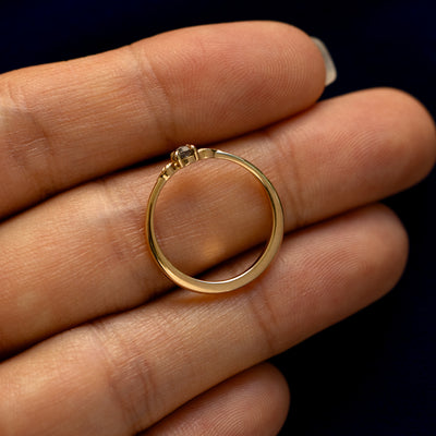 A yellow gold Smoky Quartz Gemstone Two Leaf Ring in a model's hand showing the thickness of the band