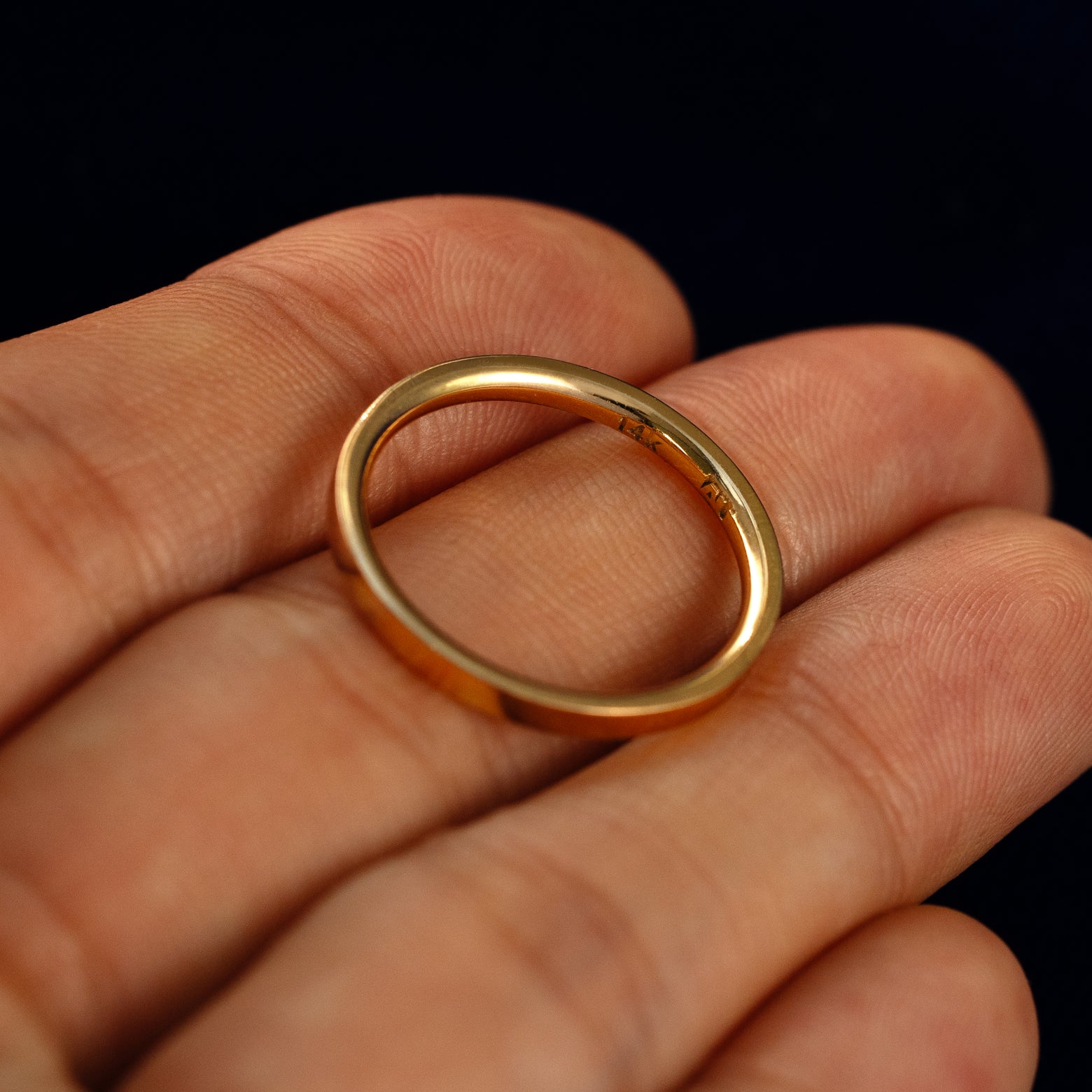 A Flush Set Baguette Diamond Ring in a model's hand showing the inside of the band