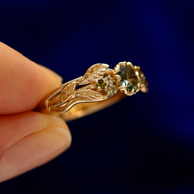 A model holding a Green Sapphire Leaves and Vines Ring 