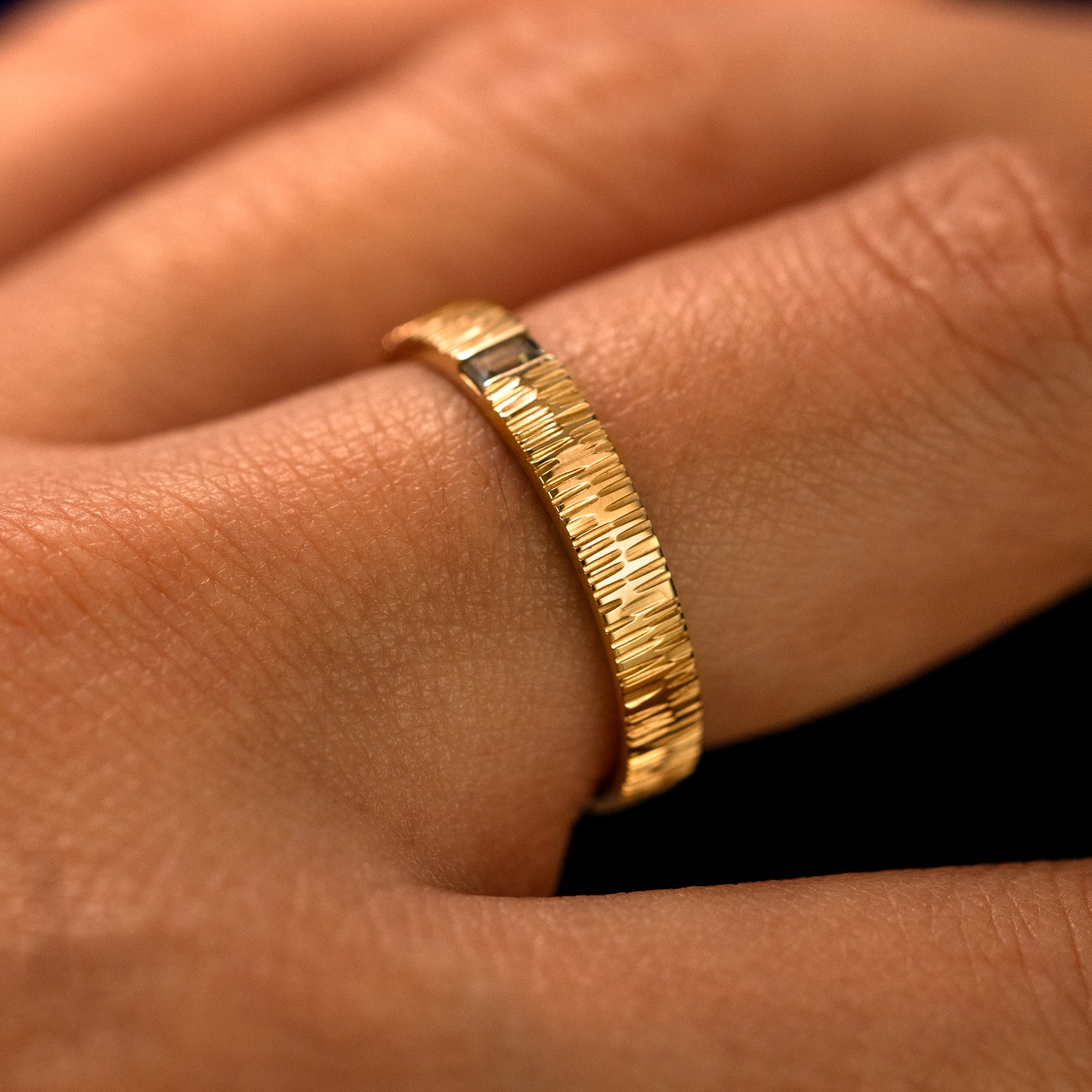 Side view of a Baguette Green Sapphire Wood Band on a model's finger