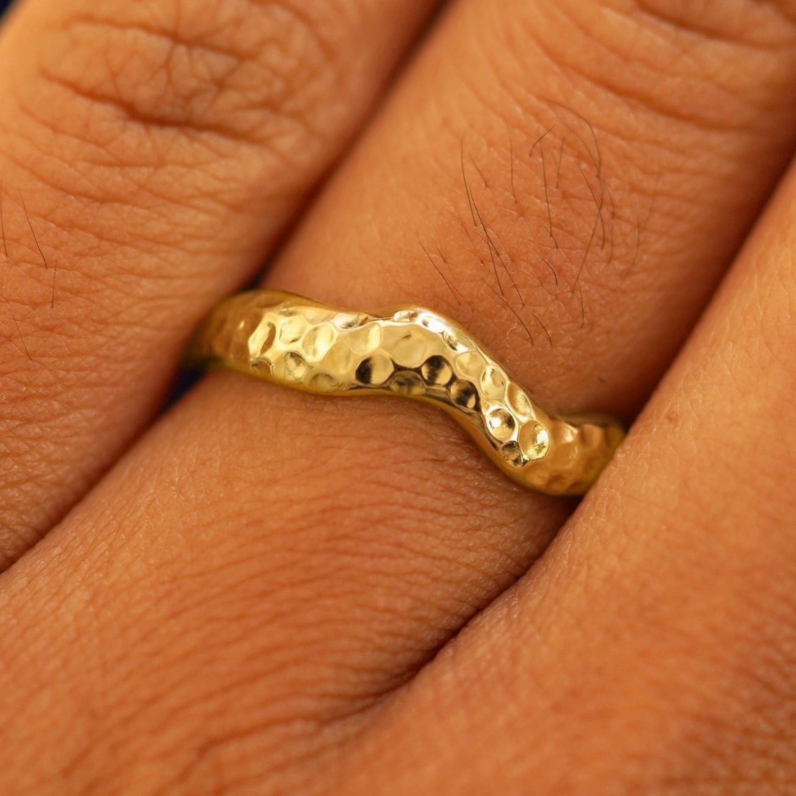 Close up view of a model's fingers wearing a 14k Hammered Liquid Band