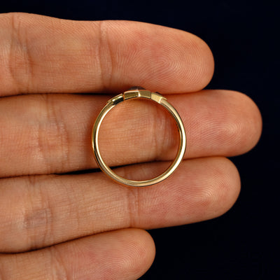 A Hexagon Salt and Pepper and Triangle Black Diamond Three Stone Ring in a model's hand showing the thickness of the band
