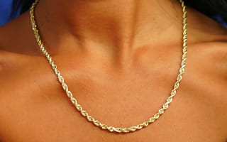 Close up view of a model's neck wearing a solid 14k yellow gold Thick Rope Chain