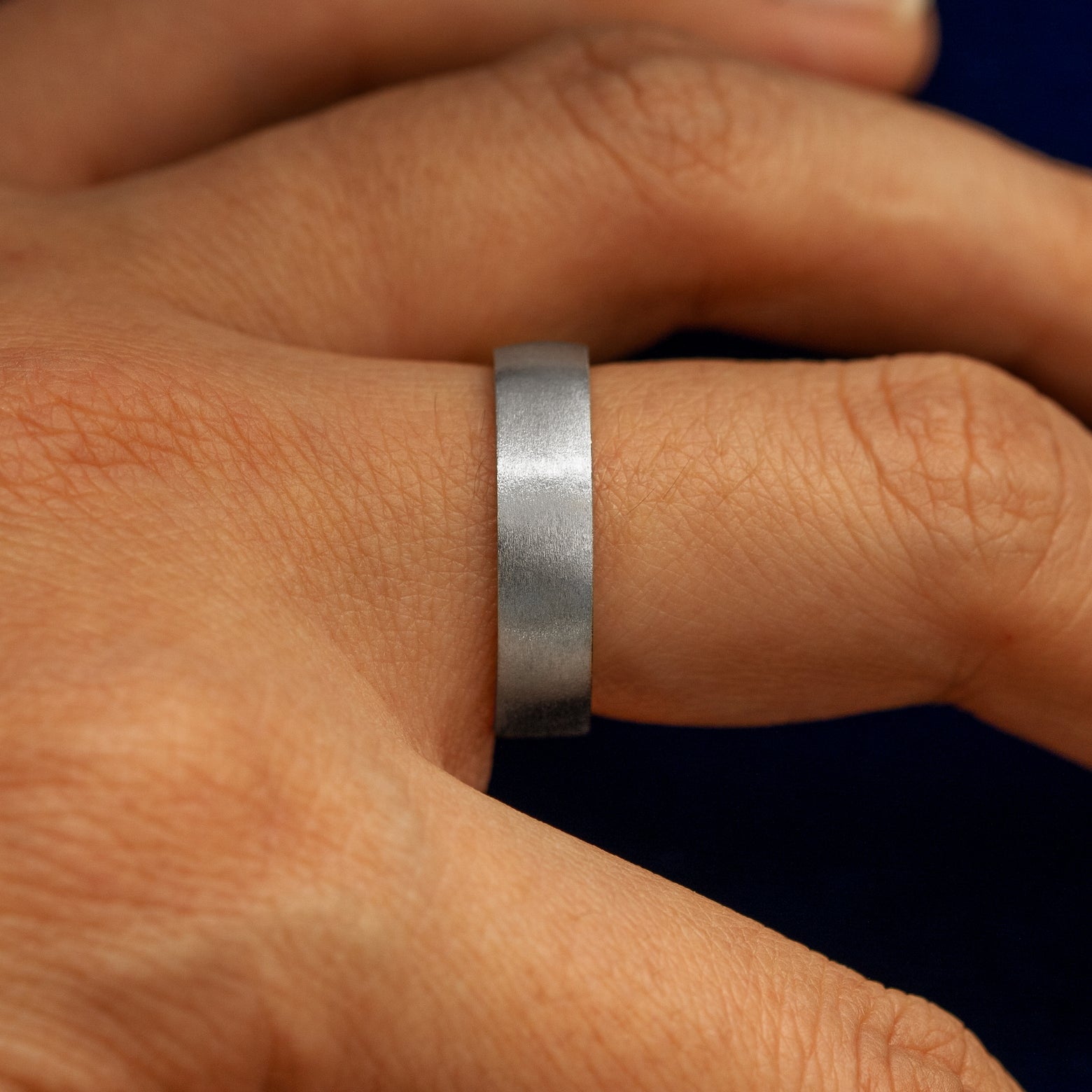 Side view of a Platinum Industrial Matte Band on a model's finger