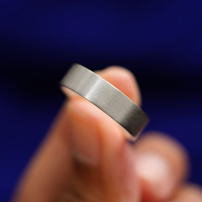 A model holding a Sterling Silver Industrial Matte Band tilted to show the details of the matte finish