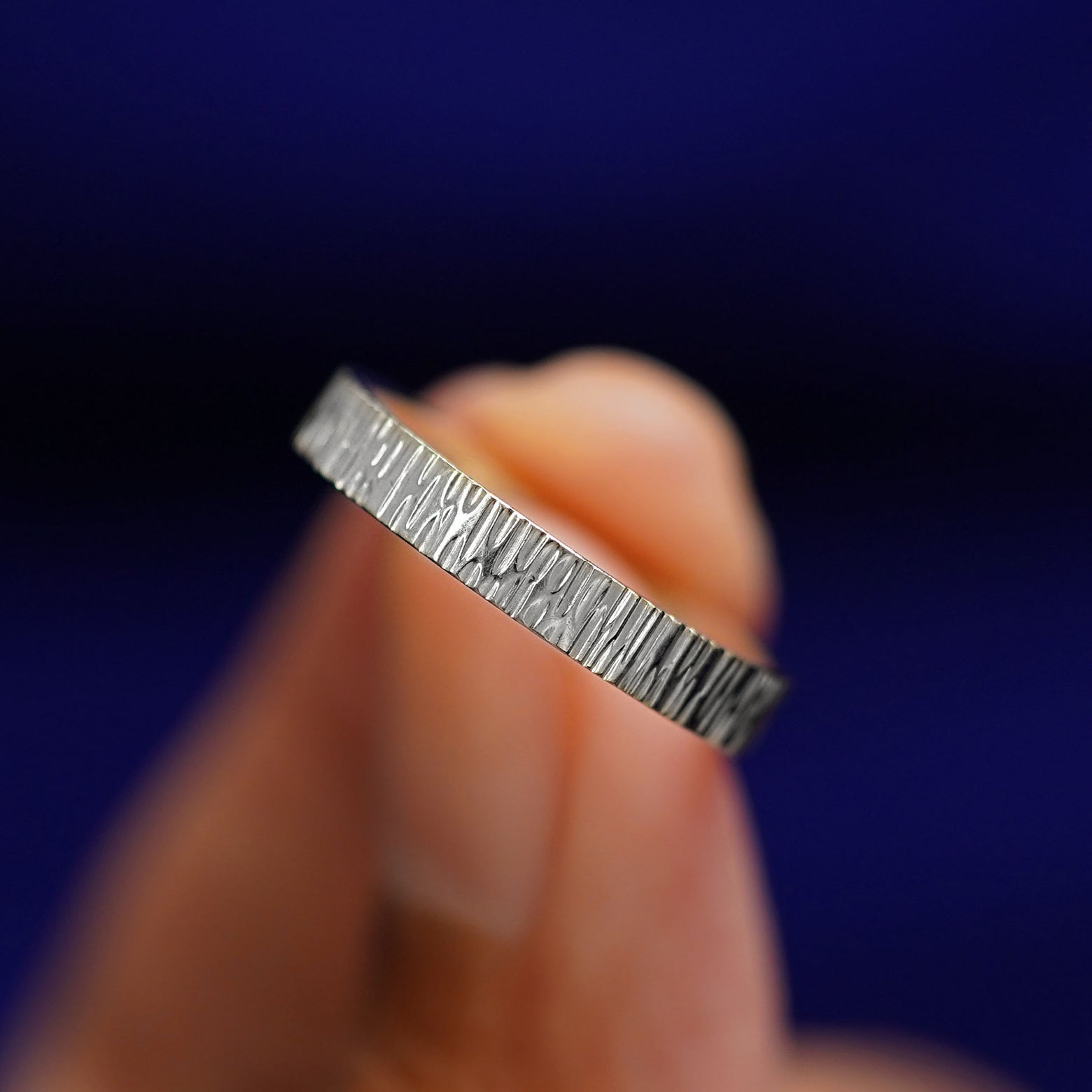 A model holding a Silver Industrial Wood Band tilted to show the details of the wood finish