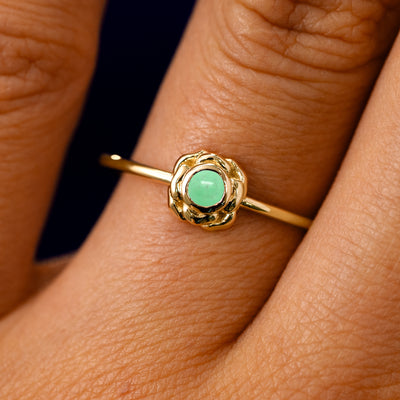 A solid 14k yellow gold Jade Gemstone Flower Ring on a model's finger