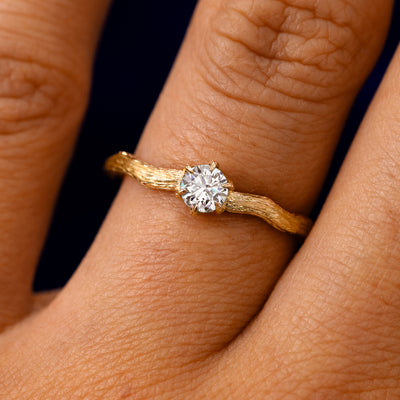 A solid 14k yellow gold Lab Diamond Waved Branch Ring on a model's finger