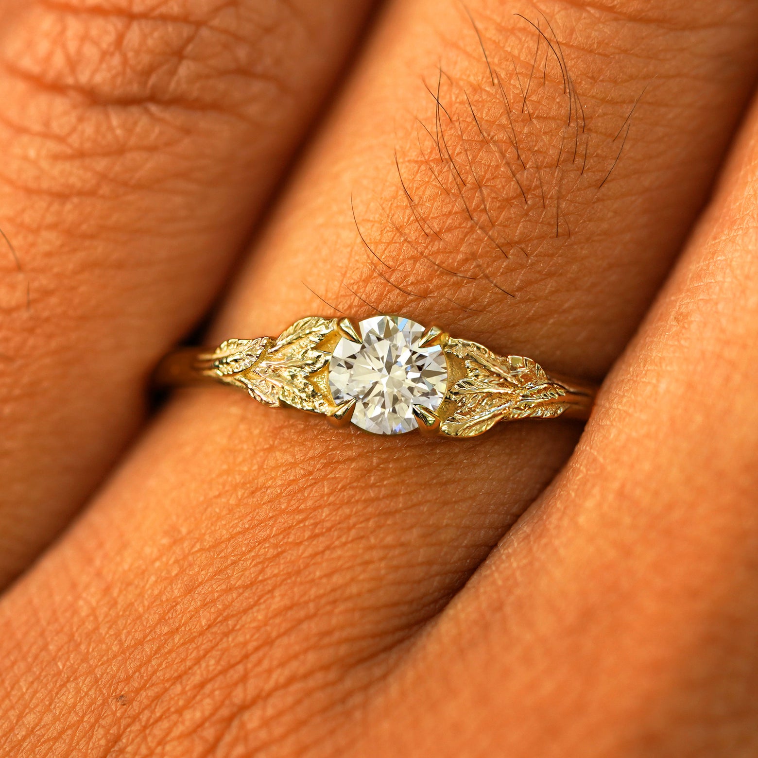 Close up view of a model's fingers wearing a 14k yellow gold Lab Diamond Leaves Ring