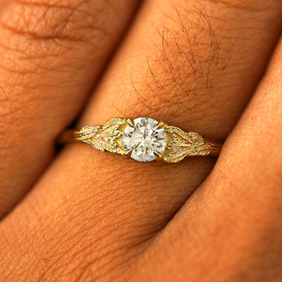 Close up view of a model's fingers wearing a 14k yellow gold Lab Diamond Leaves Ring