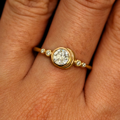 A model's hand wearing a 14k yellow gold Lab Clear Diamond Moon Ring