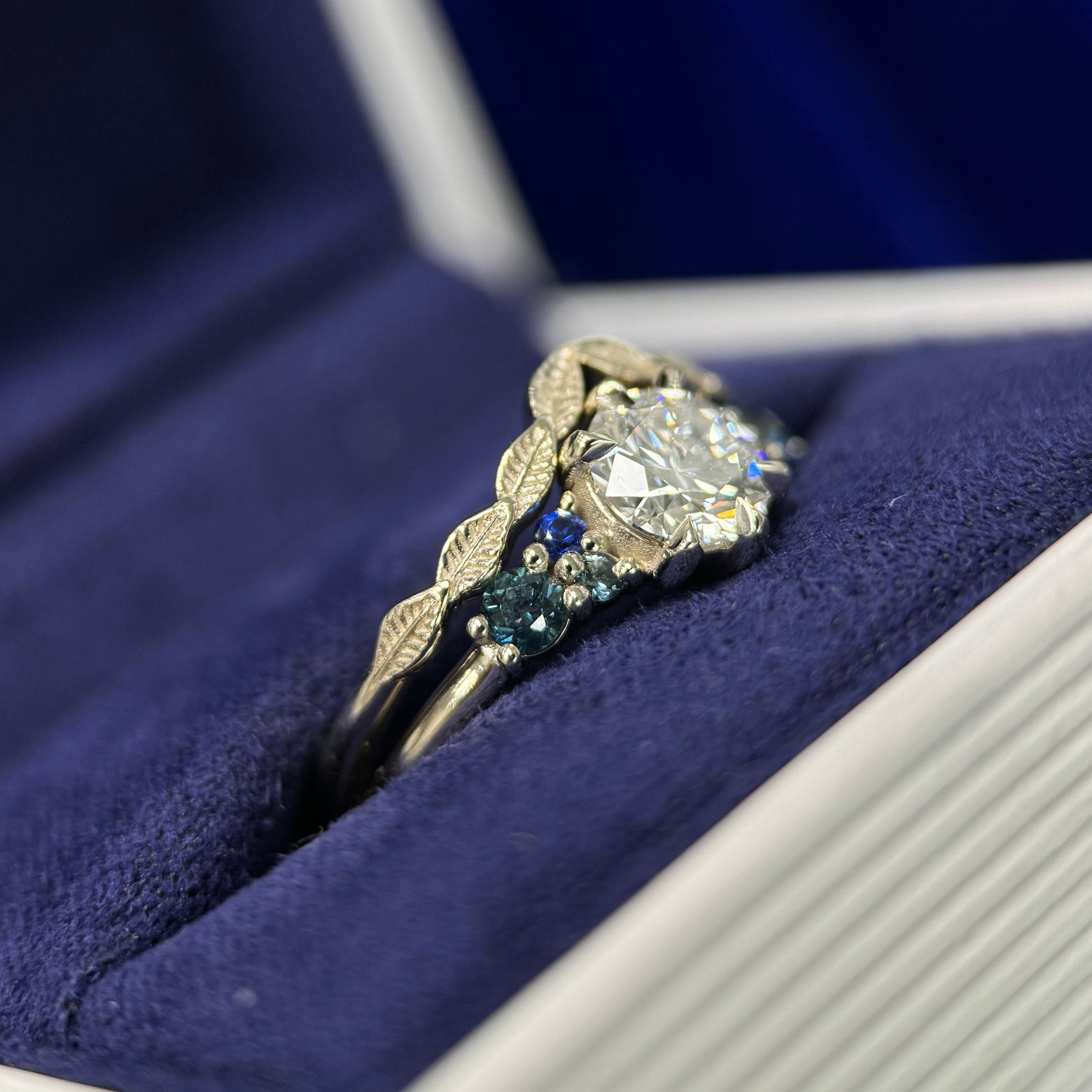 14k Champagne Gold & 6mm Round Lab Diamond & 2pc 2.7mm Customer’s Sapphires & 4pc Tiny Teal/Blue Sapphires Custom Ring & 14k Champagne Gold Nesting Leaves Custom Band