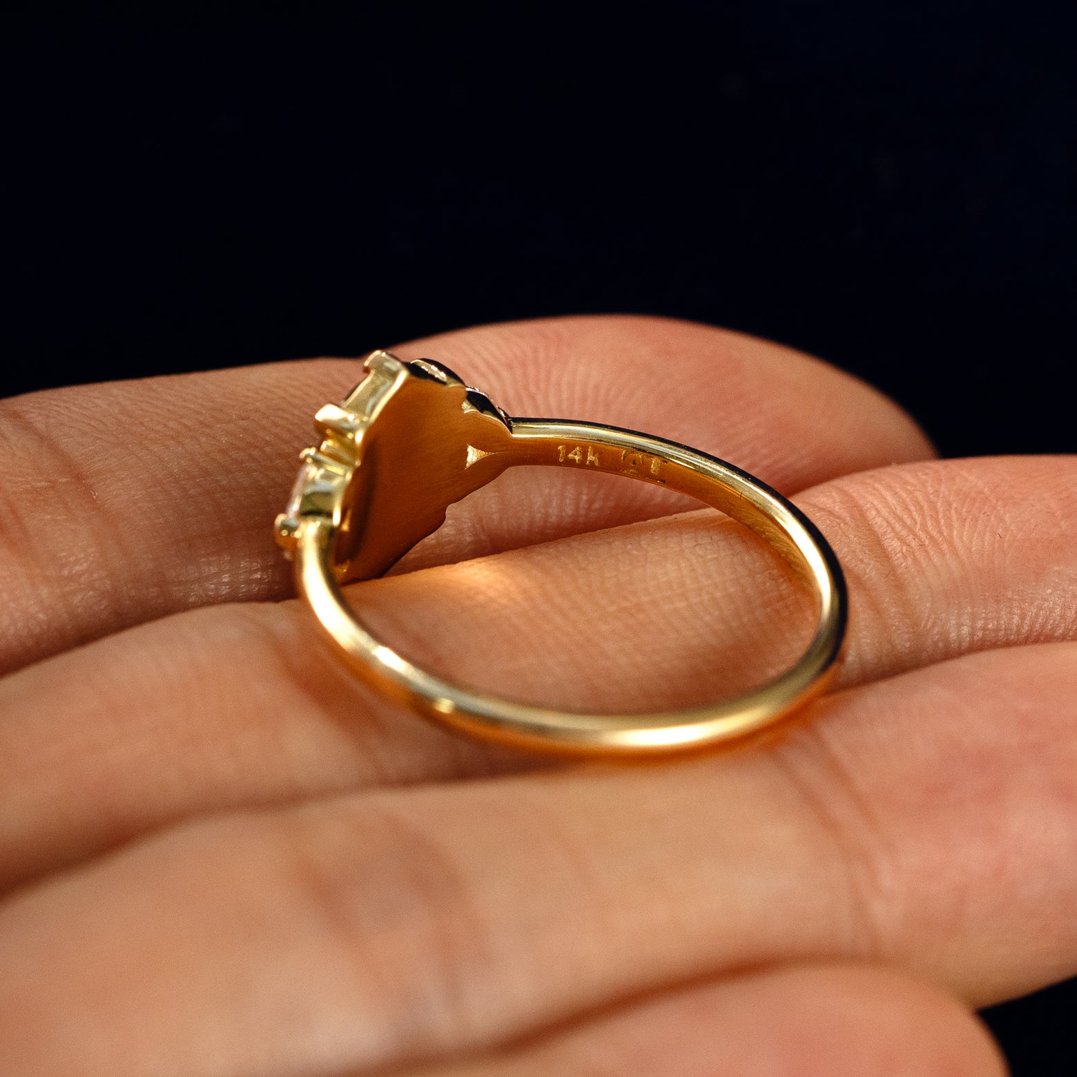 An Oval Salt and Pepper Diamond Heart Prong Ring in a model's hand showing the underside of the stones
