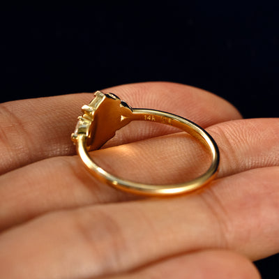 An Oval Salt and Pepper Diamond Heart Prong Ring in a model's hand showing the underside of the stones