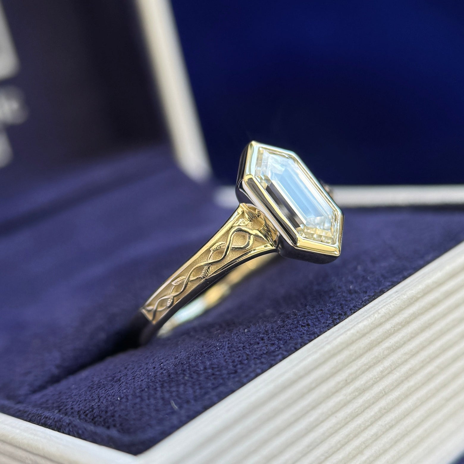 side view of 14k Champagne Gold and Bezel-set 1.4ct Elongated Hexagon Lab Diamond on Seraphine-style Celtic Engravings with Leaves Band Half-way Around the Band Custom Ring, Size 8