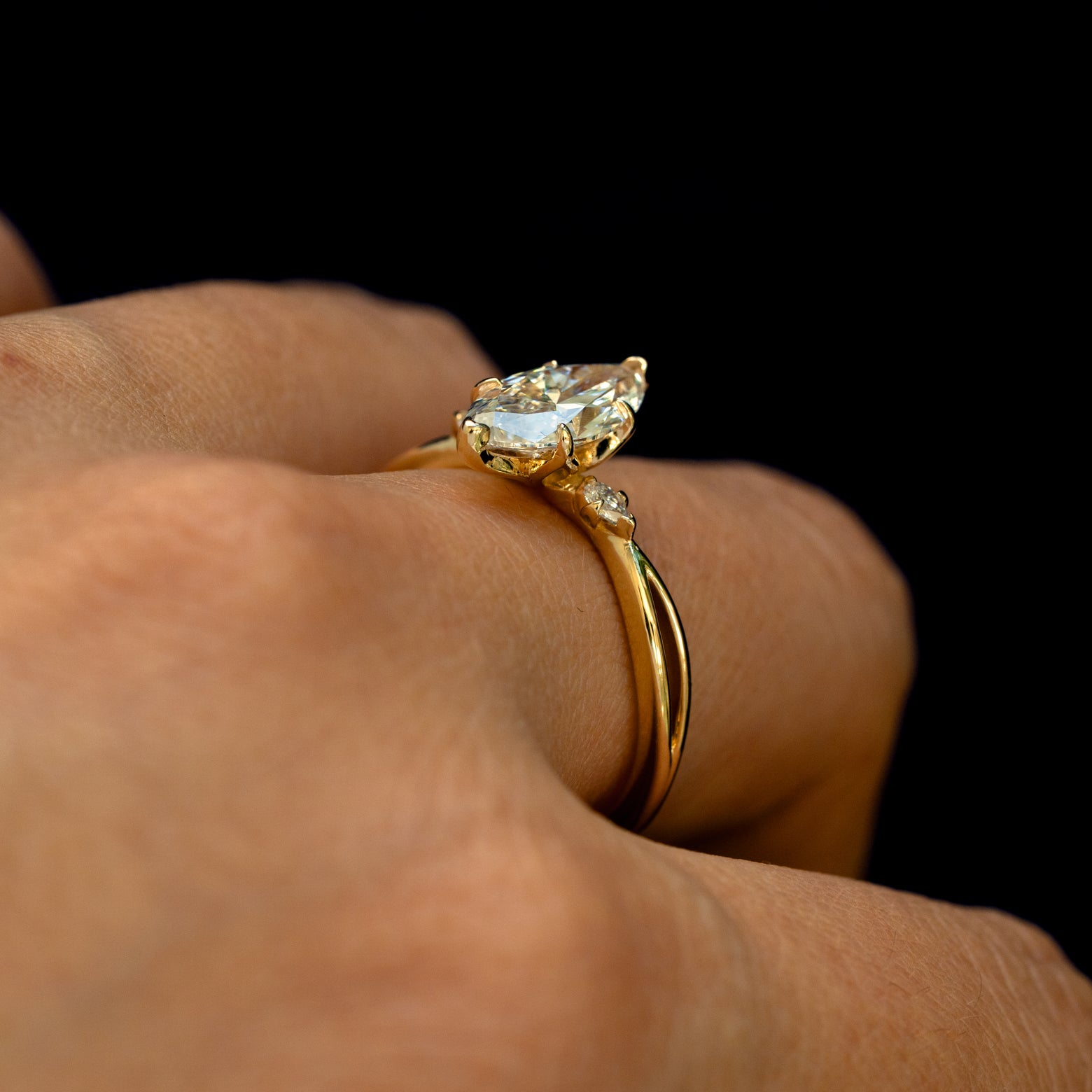 Angled view of a Marquise Lab Diamond Three Stone Ring on a model's finger to show the height of the stone