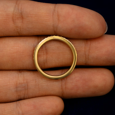 A Milgrain Pave Diamond Chevron Band lying flat in a models hand to show the thickness of the Ring
