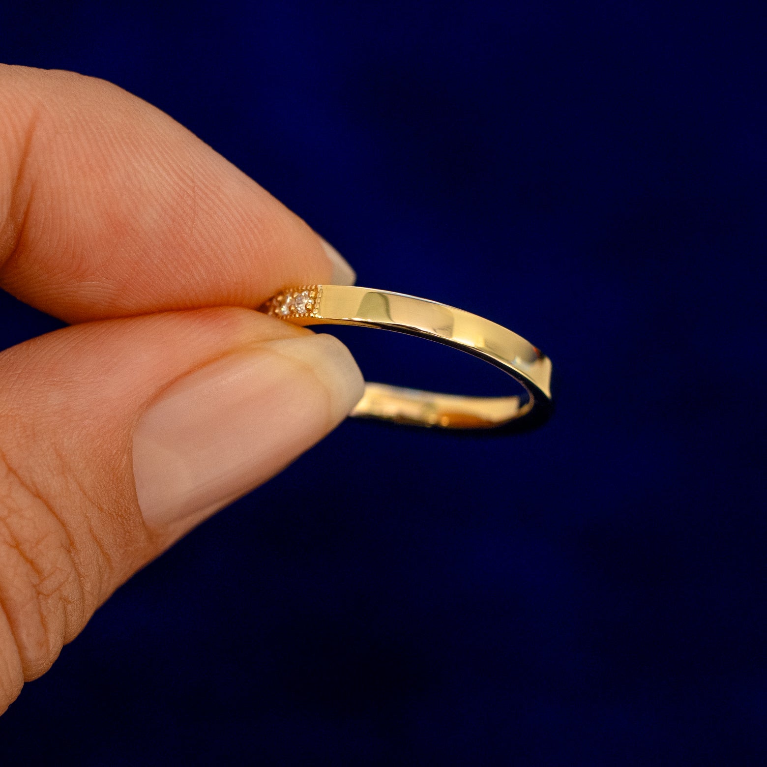 A model holding a Milgrain Pave Diamond Chevron Band backward to show the details of the back of the band