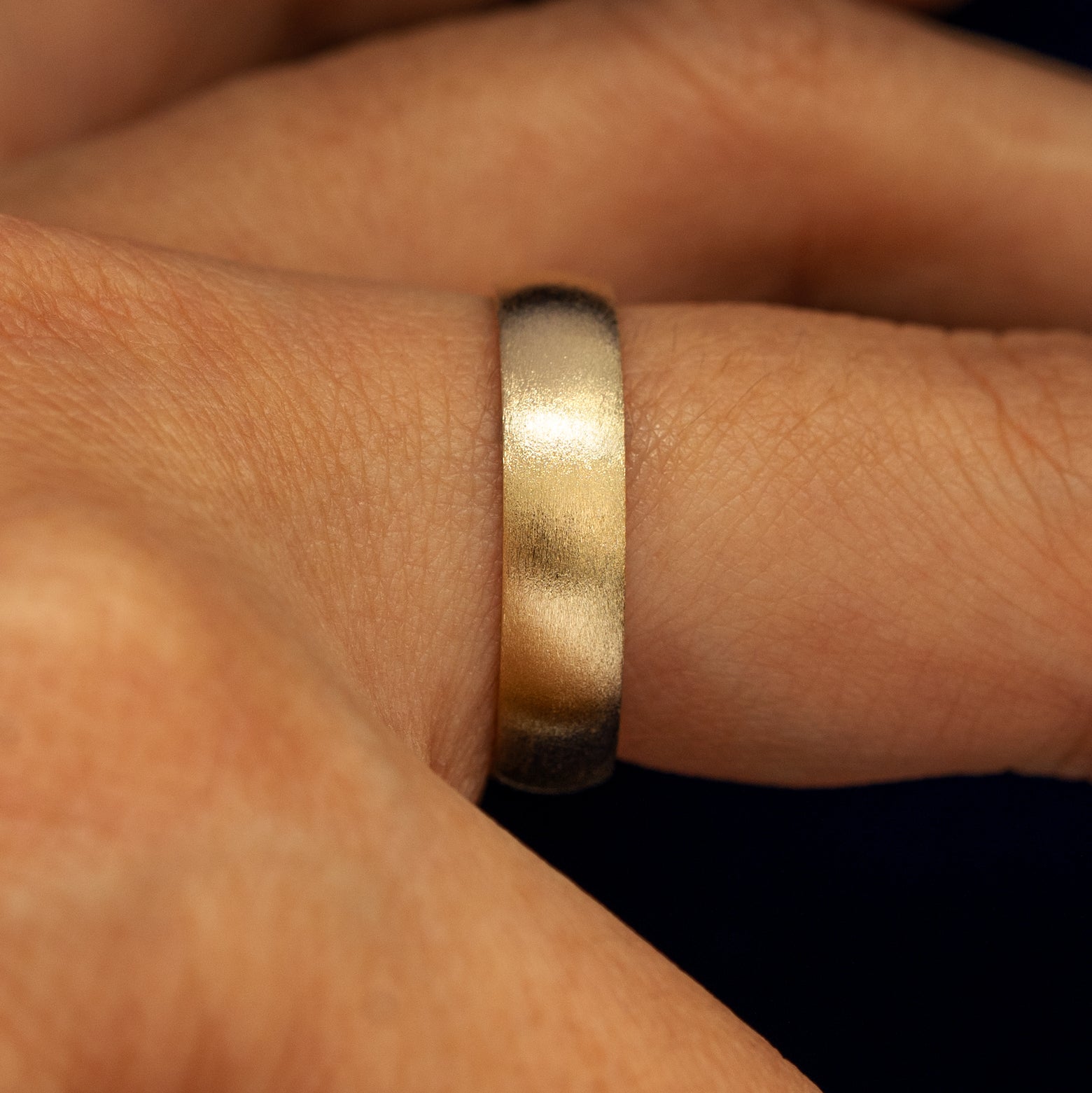 Side view of a 14 karat solid gold Mix Matte Band on a model's finger